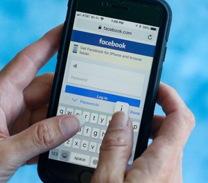 In this file photo dated Tuesday, Aug. 21, 2018, a Facebook start page is shown on a smartphone in Surfside, Fla. USA.