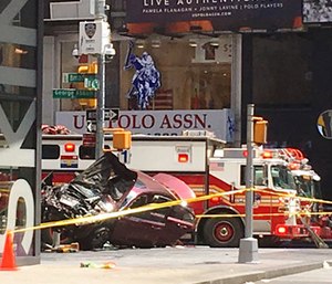 A car rests on a security barrier in New York's Times Square after driving through a crowd of pedestrians. (AP Photo/Mary Altaffer)