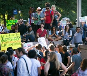 Protesters, who are against the Senate Bill 4 Sanctuary Cities ban, rally outside the Texas Department of Insurance building, where Gov. Greg Abbott has an office in Austin, Texas, Monday, May 1, 2017.