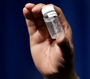 In this June 6, 2017 file photo, a reporter holds up an example of the amount of fentanyl that can be deadly after a news conference about deaths from fentanyl exposure, at The Drug Enforcement Administration headquarters in Arlington, Va.