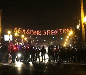 In this Nov. 25, 2014 file photo, protesters gather near the Ferguson Police Department Ferguson, Mo. (AP Image)