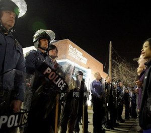 In this March 11, 2015 file photo, police and protesters square off outside the Ferguson Police Department in Ferguson, Mo.