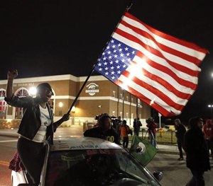 Gina Gowdy joins protesters on the street outside a Ferguson, Mo., fire station, Wednesday, March 4, 2015, in Ferguson.