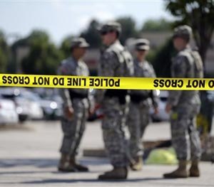 Members of the Missouri National Guard stand guard over a police command post Tuesday, Aug. 19, 2014, in Ferguson, Mo. (AP Image)