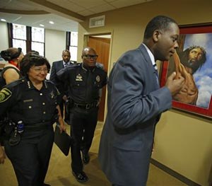 In this photo taken on Aug. 18, 2014, Dallas County District Attorney, Craig Watkins. right, with Dallas Police Chief David Brown, center, and Dallas County Sheriff Lupe Valdez walk into an open meeting at the St. Paul United Methodist Church in Dallas, to address the concerns of police shootings.