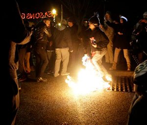 A protester burns an American flag outside the Ferguson Police Department Saturday, Nov. 29, 2014, in Ferguson, Mo. (AP Photo/Jeff Roberson)