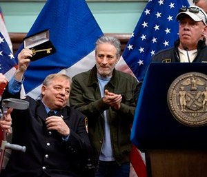 Comedian Jon Stewart joined New York Mayor Bill de Blasio to honor the cancer-stricken Sept. 11 first responder who helped win a fight for health care. (AP Photo/Craig Ruttle)