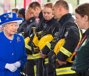 Britain's Queen Elizabeth II, left, meets firefighters and paramedics during a visit to the Westway Sports Centre which is providing temporary shelter for those who have been made homeless by the fire at Grenfell Tower.