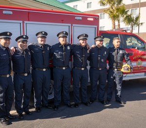 Several of the new personnel for the Victorville Fire Department are seen posing in front of a new squad vehicle.