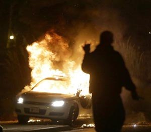 A police car is set on fire after a group of protesters vandalize the vehicle after the announcement of the grand jury decision Monday, Nov. 24, 2014, in Ferguson, Mo. (AP Image)
