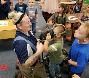 West Virginia firefighter Wendi Wentzell-Cuc shows a child her face mask during Fire Prevention Week. She and the department signed LION's 