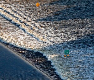 Flooding from Tropical Storm Harvey rushes over a roadway in Beaumont, Texas.