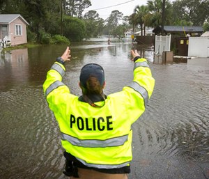 A City of Tybee police officer checks the well being of a resident fleeing her flooded home on Tybee Island, Ga.