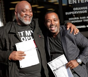 Former felons Desmond Meade, president of the Florida Rights Restoration Coalition, left, and David Ayala, husband of State Attorney Aramis Ayala, celebrate with copies of their voter registration forms after they registered at the Supervisor of Elections office Tuesday, Jan. 8, 2019, in Orlando, Fla. Former felons in Florida began registering for elections on Tuesday, when an amendment that restores their voting rights went into effect.