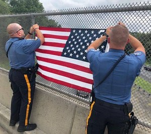 Robbinsville Township police officers hang an American flag on an overpass that runs through their Township. (Photo/Robbinsville Police Department via Facebook)