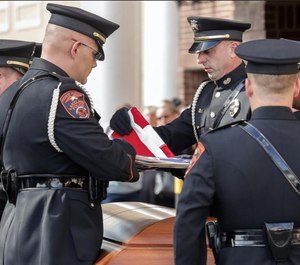Lakeland Police Honor Guard Officer Suttle prepares to hand the flag to Lakeland Police Chief Ruben Garcia during the Police Honors ceremony for Officer Paul Dunn. (Photo/TNS)
