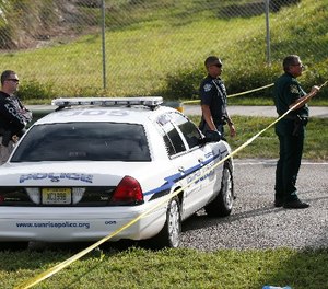 Law enforcement officers block off the entrance to Marjory Stoneman Douglas High School, Thursday, Feb. 15, 2018 in Parkland, Fla.