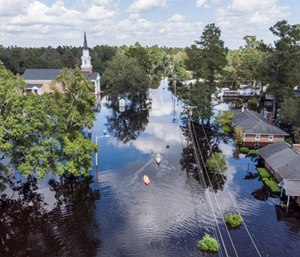 United States Coastguardsmen navigate an inflatable boat up Sherwood Drive in Conway, s.c., checking on residents. (Photo/AP)