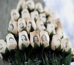 In this Jan. 14, 2013, file photo, white roses with the faces of victims of the Sandy Hook Elementary School shooting are attached to a telephone pole near the school in Newtown, Conn.