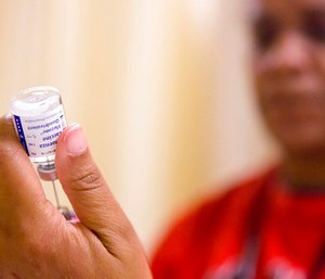 A nurse prepares a flu shot from a vaccine vial at the Salvation Army in Atlanta.