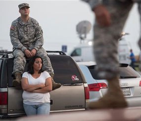 Lucy Hamlin and her husband, Spc. Timothy Hamlin, wait for permission to re-enter the Fort Hood military base, where they live, following a shooting on base on Wednesday, April 2, 2014, in Fort Hood, Texas.