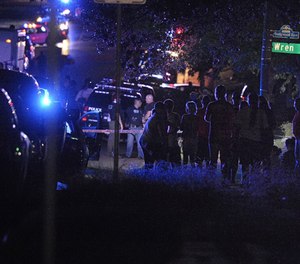Neighbors try to get some information as they watch the police staging in the Wedgwood neighborhood of Fort Worth, Texas, on Friday, Sept. 16, 2016, amid reports that two officers were shot. (Photo/Fort Worth Star-Telegram)
