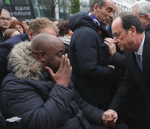 French President Francois Hollande speaks with a victim after unveiling a commemorative plaque outside the Stade de France stadium, in Saint-Denis, near Paris, France.