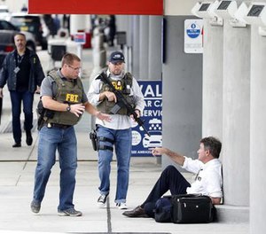 A law enforcement officers talk to a man at Fort Lauderdale–Hollywood International Airport, Friday, Jan. 6, 2017, in Fort Lauderdale, Fla.