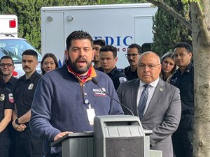 California Ambulance Association President James Pierson addresses a press conference as Assemblyman Freddie Rodriguez and EMS providers look on.