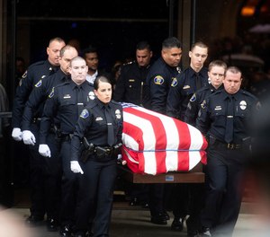 Newman police officers carry the body of their slain colleague Cpl. Ronil