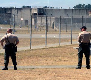 In this Aug. 17, 2011 file photo, correctional officers keep watch on inmates in the recreation yard at Pelican Bay State Prison near Crescent City, Calif.
