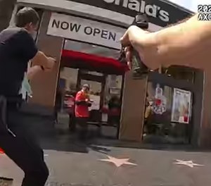 A still image taken from LAPD bodycam footage shows the moment before officers shot and killed a man who was holding what appeared to be a handgun, but was later determined to be a butane lighter.