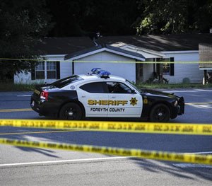 Officials in front of home.