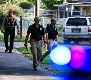Georgia Bureau of Investigation agents and Hall County Sheriff's Office deputies work a crime scene along Highland Avenue, Monday, July 8, 2019, in Gainesville Ga. (Scott Rogers/The Times via AP)