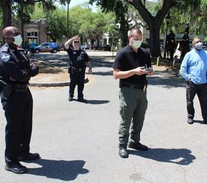 Police Chief Roy Minter (left) and other officers deploy a 'talking' drone to remind the public about social-distancing guidelines.