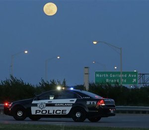 An armed police officer stands guard on a road near the Curtis Culwell Center where a provocative contest for cartoon depictions of the Prophet Muhammad was held Sunday, May 3, 2015. (AP Image)