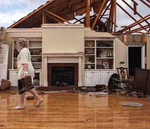 enny Bullard carries a pair of boots from her home that was damaged by a tornado, Sunday, Jan. 22, 2017, in Adel, Ga. Gov. (AP Photo/Branden Camp)