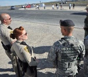 799th Security Forces Squadron and local law enforcement discuss lessons learned during a protest, March 29, 2013. Military and civilian law enforcement agencies partner together to help ensure the safety of Airmen while also protecting the First Amendment rights of U.S. citizens. (U.S. Air Force photo by Senior Master Sgt. P.H./Released)