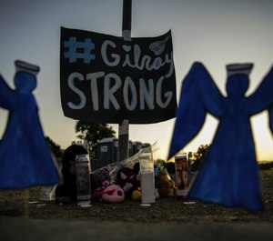 Mourners leave items at a roadside memorial in Gilroy, Calif., after a mass shooting at the Gilroy Garlic Festival last year. (Photo/TNS)