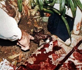 This June 13, 1994, LAPD evidence file photo shows Los Angeles Police Department's Mark Fuhrman pointing to a pieces of evidence near the body of Nicole Brown Simpson on the bloodstained walkway of her condominium. The O.J. Simpson trial has become a textbook example of what not to do at a crime scene for police and forensic workers.