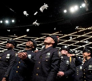 The newest members of the New York City police toss their gloves into the air during their graduation ceremony, Thursday, June 29, 2017, in New York.