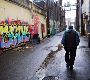 A person walks through an alley decorated with graffiti messages in downtown Aberdeen, Wash., Thursday, June 15, 2017.