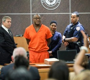 Lydell Grant, second from left, smiles in court after he was ordered to be released while authorities reinvestigate his case. (Photo/AP)