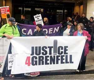 Protesters outside the Grenfell Tower public inquiry in central London where Sir Martin Moore-Bick is delivering his opening statement during its first preliminary hearing. (Jack Hardy/PA via AP)