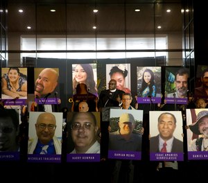 In this Dec. 7, 2015, file photo, San Bernardino County employees hold up photos of the San Bernardino shooting victims during a candlelight vigil in San Bernardino, Calif.