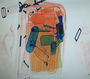 An x-rayed photo shows what appears to be a revolver, in blue at right, among other contents of a briefcase that passed through security. (Detroit Police Department via AP)