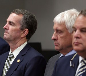 Virginia Gov. Ralph Northam, left, listens during a news conference in Virginia Beach, Va. Friday, May 31, 2019. (AP Photo/Vicki Cronis-Nohe)