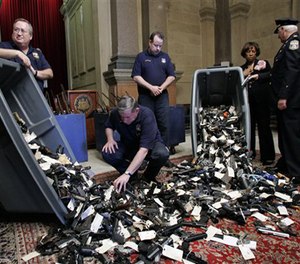 Guns are seen on display during a news conference regarding the