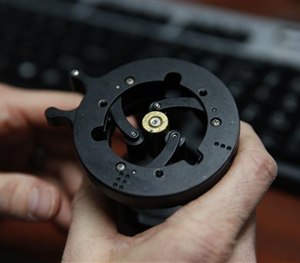 In this April 2, 2015 photo, a forensic scientist with the Colorado Bureau of Investigation, loads a bullet casing into the the National Integrated Ballistic Information Network. (AP Image)