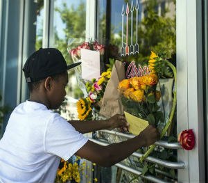 Mason Matthews, 10, leaves a card at a makeshift memorial for shooting victim Jillian Johnson at Red Arrow Workshop in River Ranch in Lafayette, La., Friday, July 24, 2015. (AP Image)